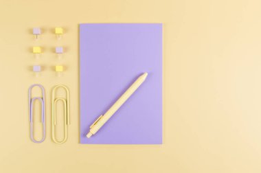 Sarı arkaplanda mor defterin üst görüntüsü. Ataç, kalem ve raptiye. Okul, ofis duvar kağıdı. Düz yat, boşluğu kopyala.