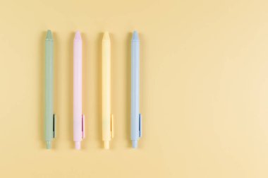 Sarı arka planda renkli kalemlerin üst görüntüsü. Okul, ofis duvar kağıdı. Düz yat, boşluğu kopyala.