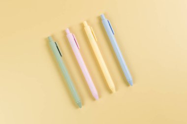 Sarı arka planda renkli kalemlerin üst görüntüsü. Okul, ofis duvar kağıdı. Düz yat, boşluğu kopyala.