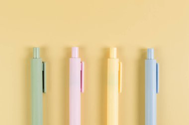 Sarı arka planda renkli kalemlerin üst görüntüsü. Okul, ofis duvar kağıdı. Düz yat, boşluğu kopyala.