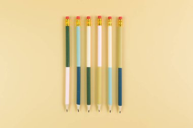 Sarı arka planda renkli kalemlerin üst görüntüsü. Okul, ofis, duvar kâğıdı. Düz yat, boşluğu kopyala.