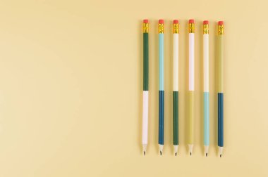 Sarı arka planda renkli kalemlerin üst görüntüsü. Okul, ofis, duvar kâğıdı. Düz yat, boşluğu kopyala.