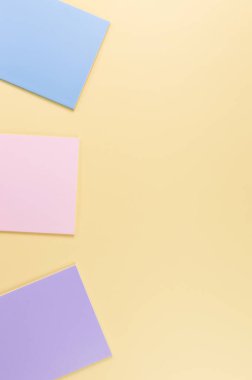 Sarı arka planda pembe, mor ve mavi defterlerin üst görüntüsü. Okul, ofis duvar kağıdı. Düz yat, boşluğu kopyala.