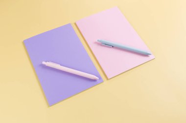 Pembe ve mor defterlerin üst görüntüsü, sarı arka planda pembe ve mavi kalemler. Okul, ofis duvar kağıdı. Düz yat, boşluğu kopyala.