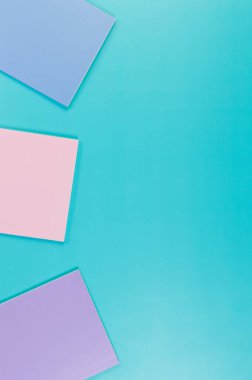 Mavi arka planda pembe, mor ve mavi defterlerin üst görüntüsü. Okul, ofis duvar kağıdı. Düz yat, boşluğu kopyala.