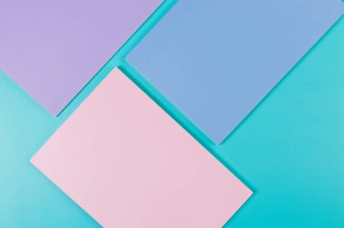 Mavi arka planda pembe, mor ve mavi defterlerin üst görüntüsü. Okul, ofis duvar kağıdı. Düz yat, boşluğu kopyala.