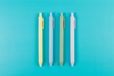 Mavi arka planda renkli kalemlerin üst görünümü. Okul, ofis duvar kağıdı. Düz yat, boşluğu kopyala.