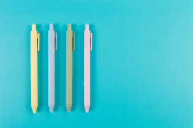 Mavi arka planda renkli kalemlerin üst görünümü. Okul, ofis duvar kağıdı. Düz yat, boşluğu kopyala.