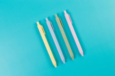 Mavi arka planda renkli kalemlerin üst görünümü. Okul, ofis duvar kağıdı. Düz yat, boşluğu kopyala.