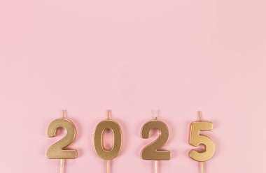 2025 mutlu yıllar. Pembe arka planda altın rakamların üst görüntüsü. Uzayı kopyala, düz yat.
