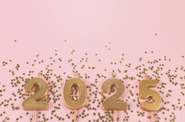 2025 mutlu yıllar. Altın sayılar manzarası, pembe arka planda altın yıldızlı konfeti. Uzayı kopyala, düz yat.