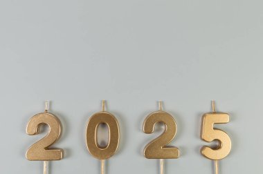 2025 mutlu yıllar. Gri arkaplandaki altın rakamlarının üst görüntüsü. Uzayı kopyala, düz yat.