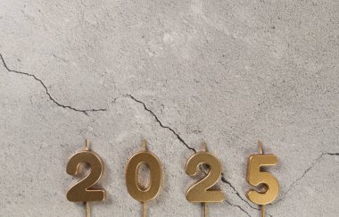 2025 mutlu yıllar. Gri beton arkaplandaki altın rakamlarının en üst görüntüsü. Uzayı kopyala, düz yat.