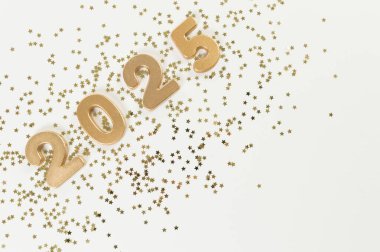 2025 mutlu yıllar. Altın sayılar manzarası, beyaz arka planda altın yıldızlı konfeti. Uzayı kopyala, düz yat.