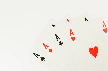 Beyaz arkaplanda kart oynamanın en üst görünümü. Dört as, masa oyunu, poker. Uzayı kopyala, düz yat.