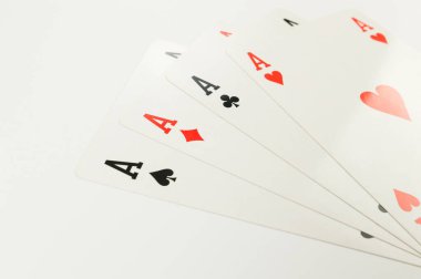 Beyaz arkaplanda kart oynamanın en üst görünümü. Dört as, masa oyunu, poker. Uzayı kopyala, düz yat.