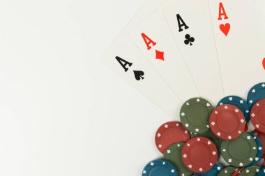 Oyun kartlarının üst görüntüsü, beyaz arka planda poker çipleri. Dört as, masa oyunu, poker. Uzayı kopyala, düz yat.