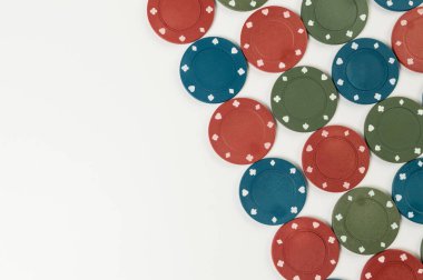 Beyaz arka planda poker çiplerinin üst görüntüsü. Bir sürü kumar fişi. Masa oyunu, oyun kartları, poker, kumarhane. Uzayı kopyala, düz yat.