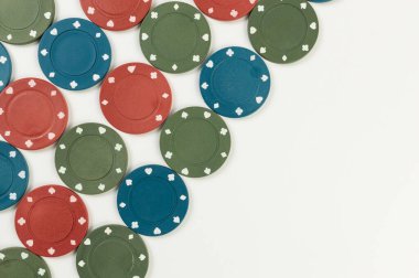 Beyaz arka planda poker çiplerinin üst görüntüsü. Bir sürü kumar fişi. Masa oyunu, oyun kartları, poker, kumarhane. Uzayı kopyala, düz yat.