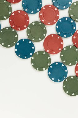 Beyaz arka planda poker çiplerinin üst görüntüsü. Bir sürü kumar fişi. Masa oyunu, oyun kartları, poker, kumarhane. Uzayı kopyala, düz yat.