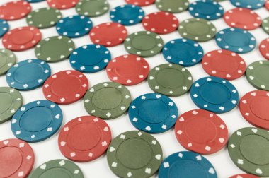 Beyaz arka planda poker çiplerinin üst görüntüsü. Bir sürü kumar fişi. Masa oyunu, oyun kartları, poker, kumarhane. Uzayı kopyala, düz yat.