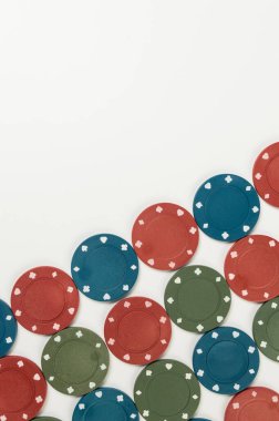 Beyaz arka planda poker çiplerinin üst görüntüsü. Bir sürü kumar fişi. Masa oyunu, oyun kartları, poker, kumarhane. Uzayı kopyala, düz yat.