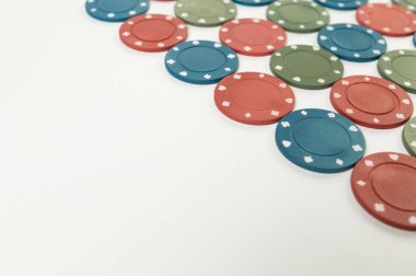 Beyaz arka planda poker çiplerinin üst görüntüsü. Bir sürü kumar fişi. Masa oyunu, oyun kartları, poker, kumarhane. Uzayı kopyala, düz yat.