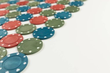 Beyaz arka planda poker çiplerinin üst görüntüsü. Bir sürü kumar fişi. Masa oyunu, oyun kartları, poker, kumarhane. Uzayı kopyala, düz yat.