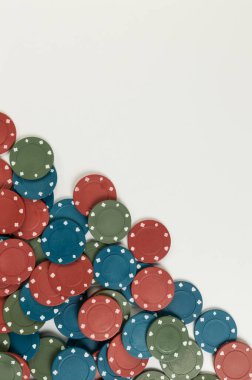 Beyaz arka planda poker çiplerinin üst görüntüsü. Bir sürü kumar fişi. Masa oyunu, oyun kartları, poker, kumarhane. Uzayı kopyala, düz yat.