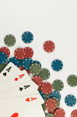 Oyun kartlarının üst görüntüsü, beyaz arka planda poker çipleri. Dört as, masa oyunu, poker. Uzayı kopyala, düz yat.