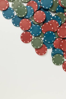 Beyaz arka planda poker çiplerinin üst görüntüsü. Bir sürü kumar fişi. Masa oyunu, oyun kartları, poker, kumarhane. Uzayı kopyala, düz yat.