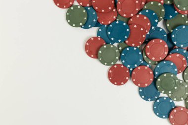 Beyaz arka planda poker çiplerinin üst görüntüsü. Bir sürü kumar fişi. Masa oyunu, oyun kartları, poker, kumarhane. Uzayı kopyala, düz yat.