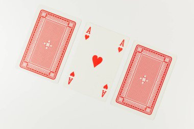 Beyaz arkaplanda kart oynamanın en üst görünümü. Üç kart, bir as kart, masa oyunu, poker. Uzayı kopyala, düz yat.