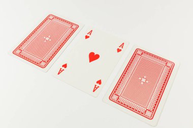 Beyaz arkaplanda kart oynamanın en üst görünümü. Üç kart, bir as kart, masa oyunu, poker. Uzayı kopyala, düz yat.