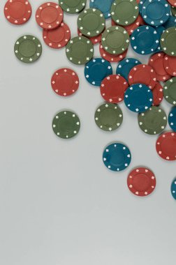 Gri arkaplandaki poker çiplerinin üst görüntüsü. Bir sürü kumar fişi. Masa oyunu, oyun kartları, poker, kumarhane. Uzayı kopyala, düz yat.