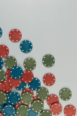Gri arkaplandaki poker çiplerinin üst görüntüsü. Bir sürü kumar fişi. Masa oyunu, oyun kartları, poker, kumarhane. Uzayı kopyala, düz yat.