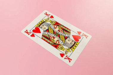 Pembe arka planda kart oynamanın en üst görüntüsü. Bir papaz kartı, masa oyunu, poker. Uzayı kopyala, düz yat.