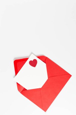 Kırmızı zarfın üst görüntüsü, beyaz arka planda beyaz kart. Sevgililer günü, kırmızı kalp, aşk. Düz yatay, kopyala boşluk.