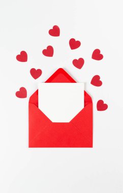 Kırmızı zarfın üst görüntüsü, beyaz arka planda beyaz kart. Sevgililer günü, kırmızı kalpler, aşk. Düz yatay, kopyala boşluk.