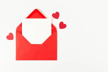 Kırmızı zarfın üst görüntüsü, beyaz arka planda beyaz kart. Sevgililer günü, kırmızı kalpler, aşk. Düz yatay, kopyala boşluk.