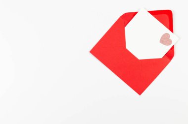 Kırmızı zarfın üst görüntüsü, beyaz arka planda beyaz kart. Sevgililer günü, pembe pırıltılı kalp, aşkım. Düz yatay, kopyala boşluk.