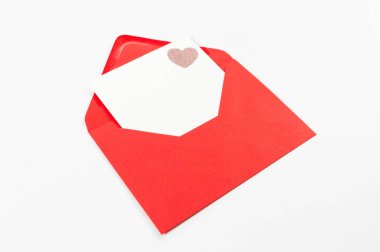 Kırmızı zarfın üst görüntüsü, beyaz arka planda beyaz kart. Sevgililer günü, pembe pırıltılı kalp, aşkım. Düz yatay, kopyala boşluk.