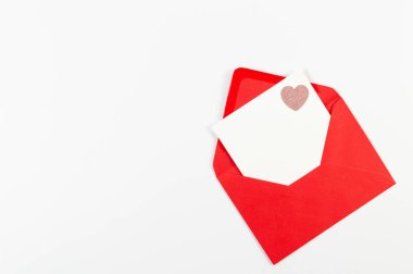 Kırmızı zarfın üst görüntüsü, beyaz arka planda beyaz kart. Sevgililer günü, pembe pırıltılı kalp, aşkım. Düz yatay, kopyala boşluk.