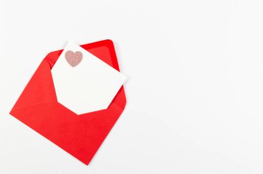 Kırmızı zarfın üst görüntüsü, beyaz arka planda beyaz kart. Sevgililer günü, pembe pırıltılı kalp, aşkım. Düz yatay, kopyala boşluk.