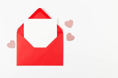 Kırmızı zarfın üst görüntüsü, beyaz arka planda beyaz kart. Sevgililer günü, pembe parıltılı kalpler, aşkım. Düz yatay, kopyala boşluk.