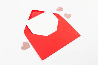 Kırmızı zarfın üst görüntüsü, beyaz arka planda beyaz kart. Sevgililer günü, pembe parıltılı kalpler, aşkım. Düz yatay, kopyala boşluk.