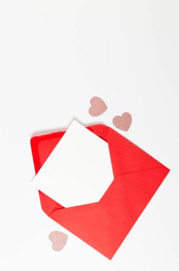 Kırmızı zarfın üst görüntüsü, beyaz arka planda beyaz kart. Sevgililer günü, pembe parıltılı kalpler, aşkım. Düz yatay, kopyala boşluk.