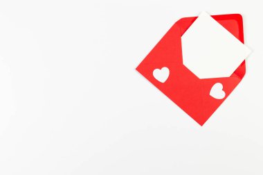 Kırmızı zarfın üst görüntüsü, beyaz arka planda beyaz kart. Sevgililer günü, beyaz kalpler, aşk. Düz yatay, kopyala boşluk.