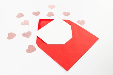 Kırmızı zarfın üst görüntüsü, beyaz arka planda beyaz kart. Sevgililer günü, pembe parıltılı kalpler, aşkım. Düz yatay, kopyala boşluk.