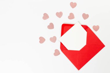 Kırmızı zarfın üst görüntüsü, beyaz arka planda beyaz kart. Sevgililer günü, pembe parıltılı kalpler, aşkım. Düz yatay, kopyala boşluk.